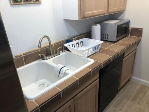 a kitchen counter with a sink and a microwave at La Mesa House, a large modern home in Santa Barbara