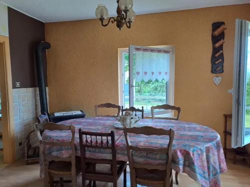 une salle à manger avec une table et des chaises et une fenêtre dans l'établissement Maison de charme à Rougegoutte avec jardin et barbecue, à Rougegoutte