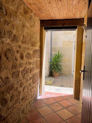 une porte ouverte menant à une chambre dotée d'un mur en pierre. dans l'établissement Appartement hôtel neuf , Bordeaux, à Bordeaux