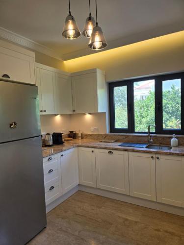 a kitchen with white cabinets and a refrigerator at Villa Mulberry - Kyrenia North Cyprus in Lapithos