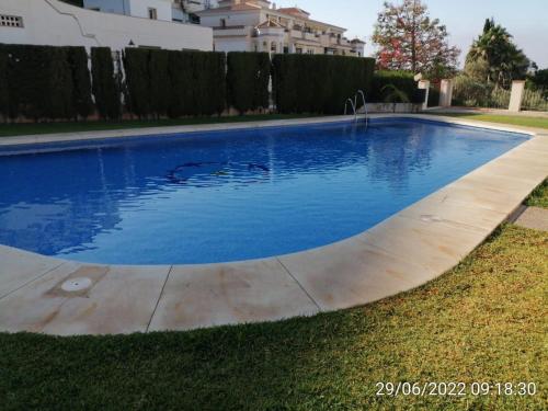 a swimming pool with blue water in a yard at VILLA PITATO Nuevo, cerca de la Playa, Parking en la puerta del alojamiento in Cala del Moral