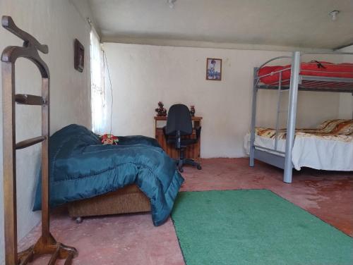 a bedroom with two bunk beds and a desk at Rancho Tlalinantli in San Miguel Ajusco