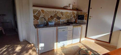 a small kitchen with a sink and a stove at La casetta a due passi dal mare in Capo Coda Cavallo