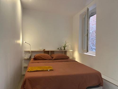 un lit dans une chambre blanche avec une fenêtre dans l'établissement appartement architecte, à Marseille