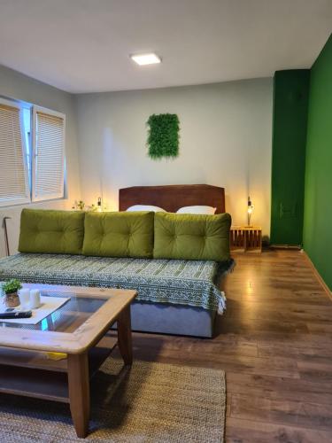 ein Wohnzimmer mit einer grünen Couch und einem Tisch in der Unterkunft Veljanov Apartment 1 in Negotino