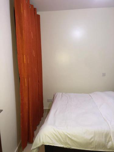 a bedroom with a bed and a wooden door at 3 Bedroom Retreat Apartment In Greatwall Gardens in Athi River