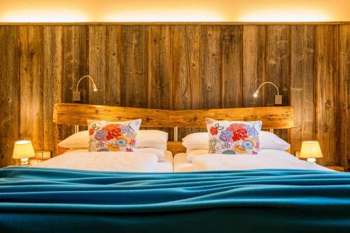 a bedroom with two beds and wooden walls at Das Bäckergut am Haldensee in Haldensee
