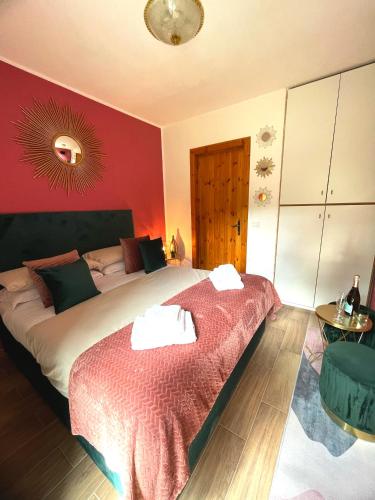 a bedroom with a large bed with a red wall at Artemide Domus in Pescocostanzo
