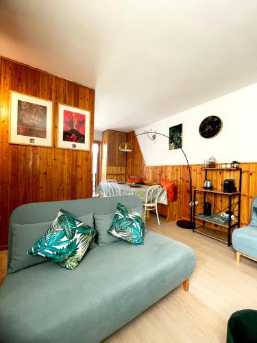 a living room with a green couch with two pillows at Artemide Domus in Pescocostanzo