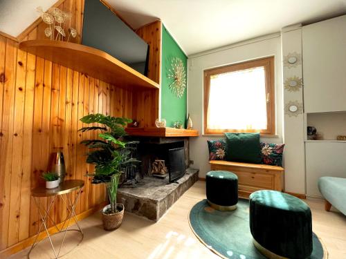 a living room with a fireplace and green walls at Artemide Domus in Pescocostanzo