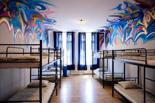 a room with a colorful mural on the wall at Hostel Graffiti in Kraków