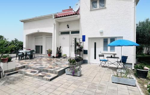Casa con patio con sombrilla azul en Cozy Apartment In Vrsi With Wifi, en Vrsi