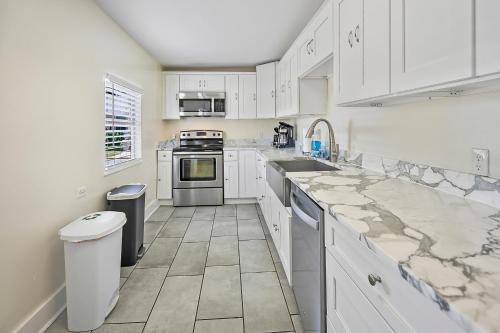a kitchen with white cabinets and marble counter tops at Villa Riberia in St. Augustine