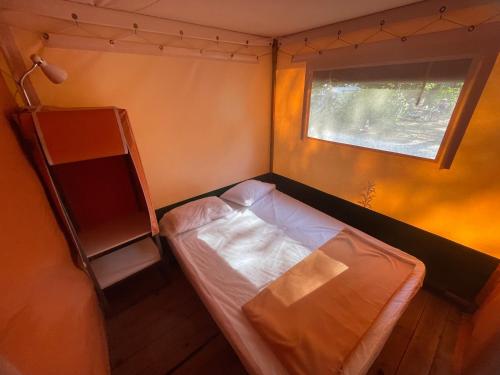Cette petite chambre comprend un lit et une étagère. dans l'établissement Camping Sainte Victoire, à Beaurecueil