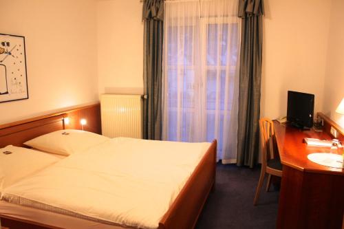 Habitación de hotel con cama, escritorio y lavabo. en Hotel Gasthaus Bock, en Reichenbach an der Fils