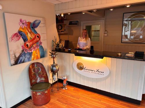 a woman standing at a counter in a salon at Welcome Inn Hotel Lyngskroa in Oteren