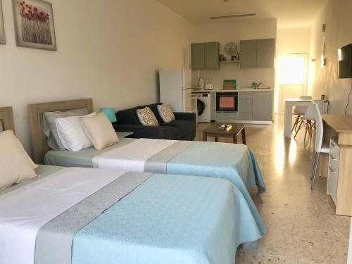 a bedroom with two beds and a living room at White House studio with sea view and parking in Polis Chrysochous