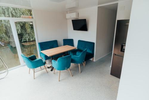 a conference room with a wooden table and blue chairs at Danubiu House Boat in Murighiol