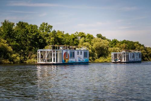 two boats are docked on a river at Danubiu House Boat in Murighiol