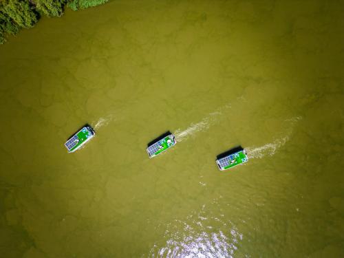 three boats in a body of water at Danubiu House Boat in Murighiol