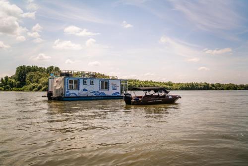 a boat is parked next to a house on the water at Danubiu House Boat in Murighiol