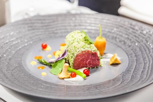 a plate with a piece of cake and vegetables on it at Galaxy Hotel in Kraków