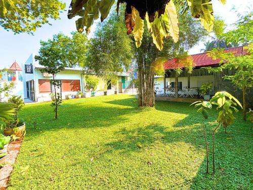 a yard with a tree in front of a house at The Ivy Lake in Anuradhapura