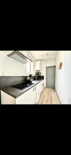 une cuisine avec des armoires blanches et un comptoir dans l'établissement Glycine, à Orléans