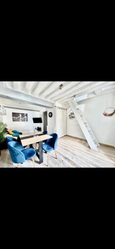 a dining room with a table and blue chairs at Glycine in Orléans