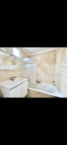 une salle de bain avec un lavabo et une baignoire dans l'établissement Glycine, à Orléans