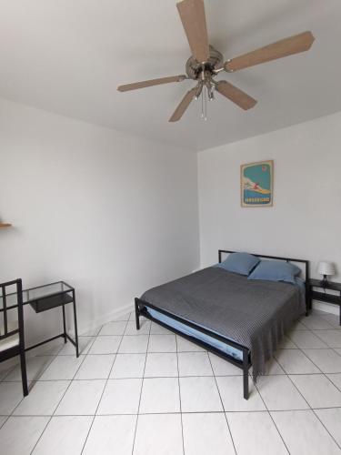 une chambre avec un lit et un ventilateur de plafond dans l'établissement Appart au calme 3 chambres 73m2 1er étage, à Bayonne