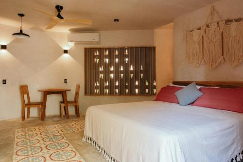 a bedroom with a bed and a table and a window at Quiote Quiote in Puerto Escondido