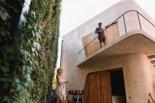 a man and a woman standing on the balcony of a building at Quiote Quiote in Puerto Escondido