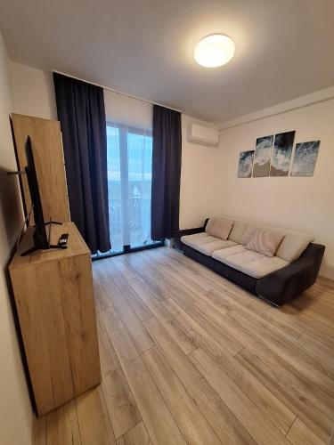 a living room with a couch and a television at AquaTherm Felix in Sînmartin