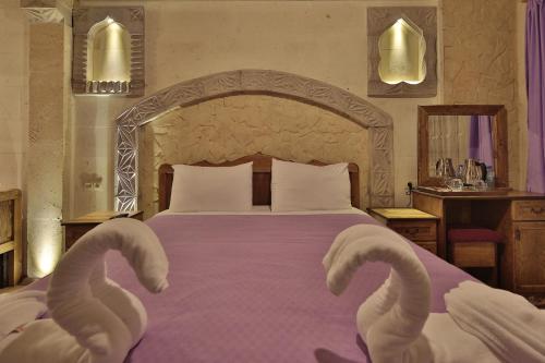 a bedroom with a large bed with swans on it at Relic House in Goreme