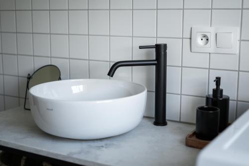 a bathroom with a white sink and a faucet at Celý apartmán v rodinném domě s vanou a krbem in Česká Třebová