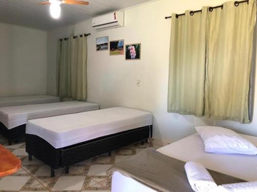 una stanza con due letti e una finestra di Clube de pesca e pousada boa sorte a Itauçu