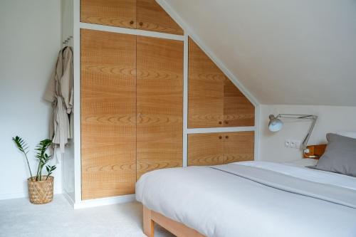a bedroom with a bed and a wooden closet at Celý apartmán v rodinném domě s vanou a krbem in Česká Třebová