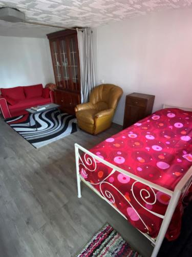 sypialnia z łóżkiem, kanapą i krzesłem w obiekcie Joli Maison calme 10 Mn de Paris st LAZARE w mieście Argenteuil