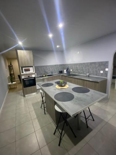 a kitchen with a table with chairs and an oven at Maison de village spacieuse et calme in Tréveray