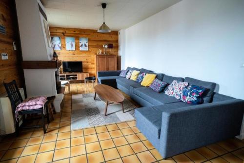 un salon avec un canapé bleu et une table dans l'établissement Chalet les 3 Porches - maeva Home - Chalet 6 pièces 15 personnes - Exclusive MAE-3221, à Vars