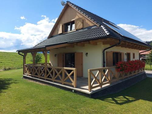 a small house with a large porch with a porch at CHALUPY TRI GROŠE VLAŠKY in Bešeňová