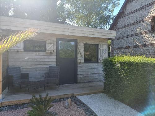 a house with a porch with chairs and a door at Le Temps d'un Instant in Vattetot-sur-Mer