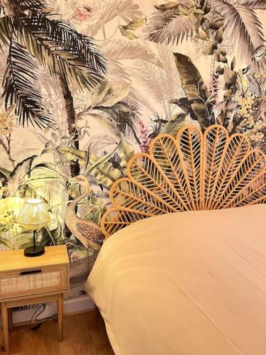 une chambre avec un lit avec un papier peint tropical dans l'établissement Jungle Haven - Romans-sur-Isère, à Romans-sur-Isère