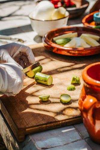 a person cutting up vegetables on a cutting board at Hotel & Spa La Ferme El Dar in Marrakech