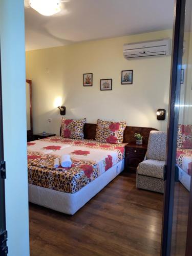 a bedroom with a bed and a chair at Guest House Debar in Arbanasi