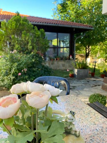 a table with a vase of roses on top of it at Guest House Debar in Arbanasi
