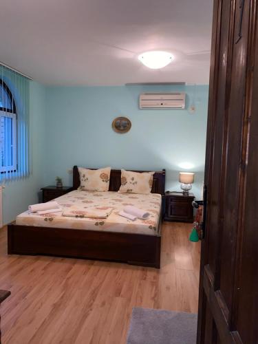 a bedroom with a bed with blue walls and wooden floors at Guest House Debar in Arbanasi