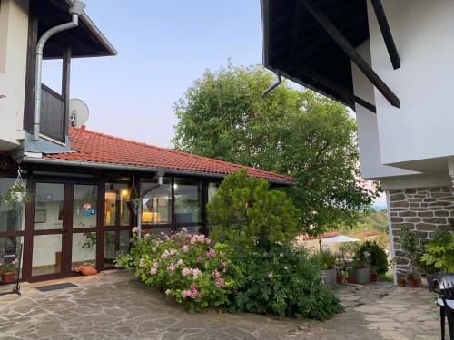 a building with a bunch of flowers in front of it at Guest House Debar in Arbanasi