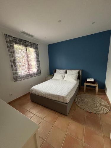une chambre avec un lit avec un mur bleu dans l'établissement Villa entre mer et golf, à Saint-Raphaël